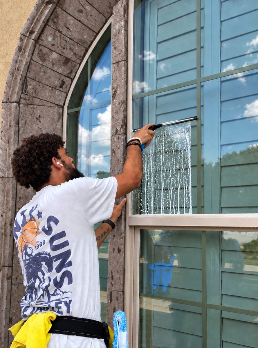 Technician squeegeeing a window