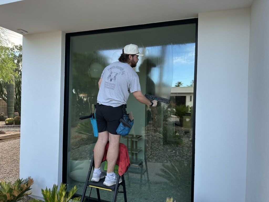 Tyler cleaning a large picture window